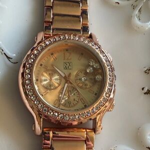 NY&C wristwatch is a rose gold-toned model featuring floating crystals